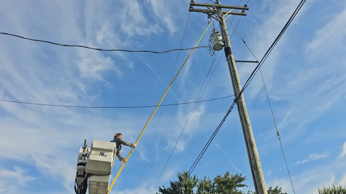 Lineman working from a bucket truck with a hot stick