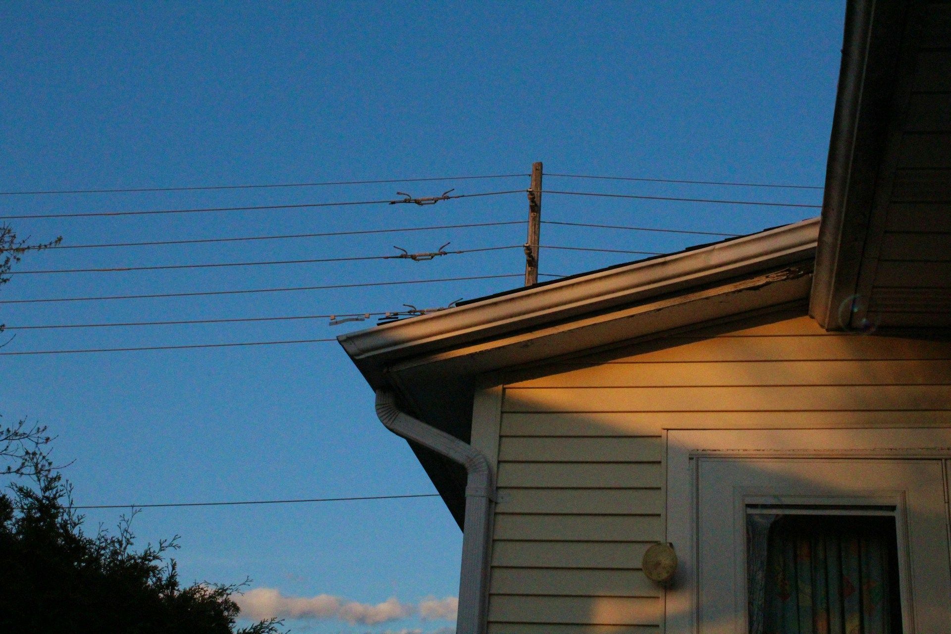 A home with dark windows and power lines